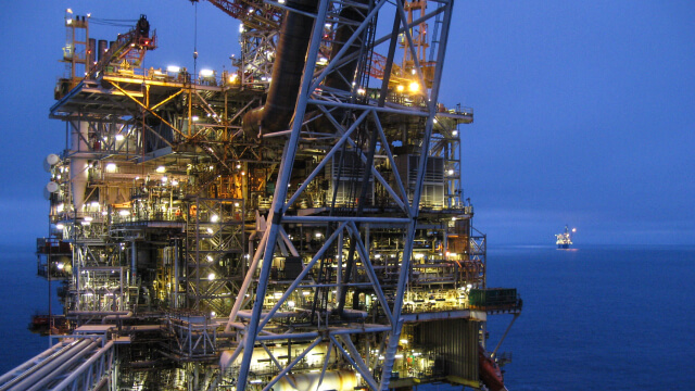 Offshore oil platform illuminated at dusk