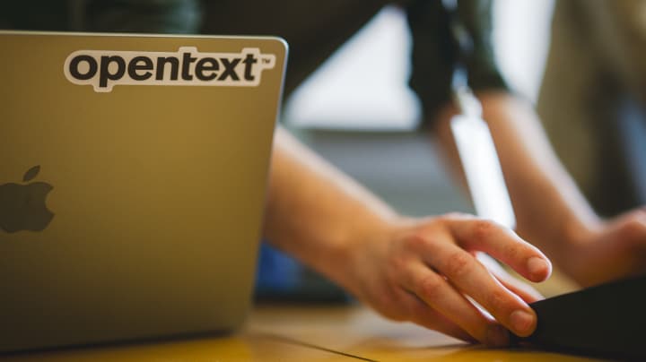 Mac laptop with OpenText sticker