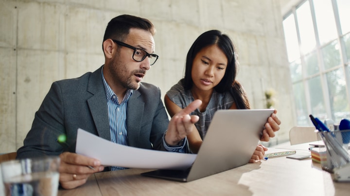 Colleagues reviewing insurance documents on a computer