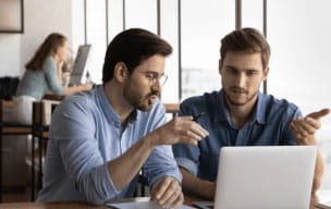 Two person working together on a laptop