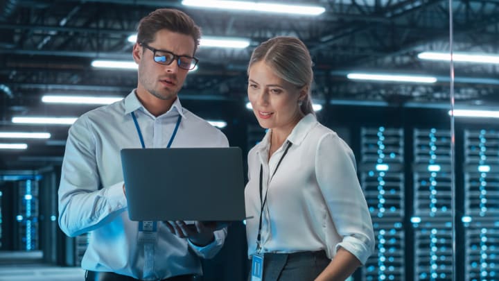 2 compañeros de trabajo mirando un portátil