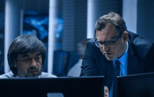 Two people working on computers in the financial industry