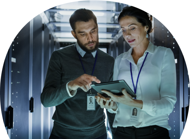 Two people inside a data centre looking at a tablet