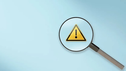 Magnifying glass over alert icon