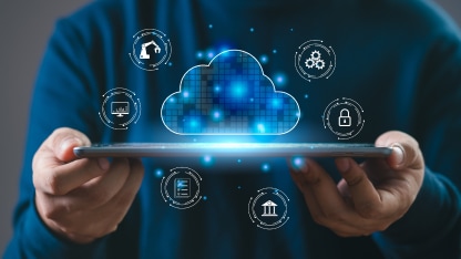 A person holding an ipad with holographic cloud icons around it