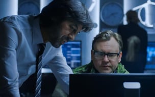 Two people discussing something while looking at a monitor screen