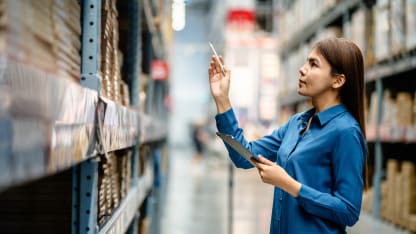Person checking the stock inventory in large warehouses