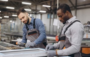 Two people assembling components on a production line