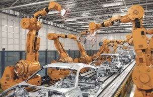 Automated robotic arms assembling cars on a production line