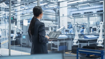 Business woman looking out over manufacturing floor