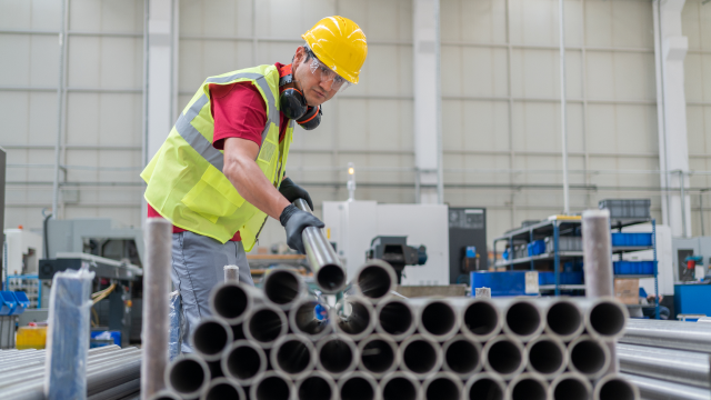 Men holding metal pipe