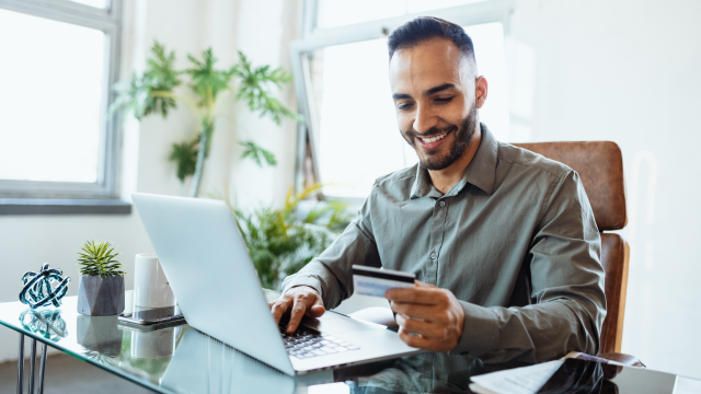 A person typing their credit card details on a laptop