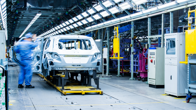 A person inspecting a vehicle in an automotive facility