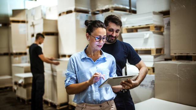 Two person checking stock list on laptop