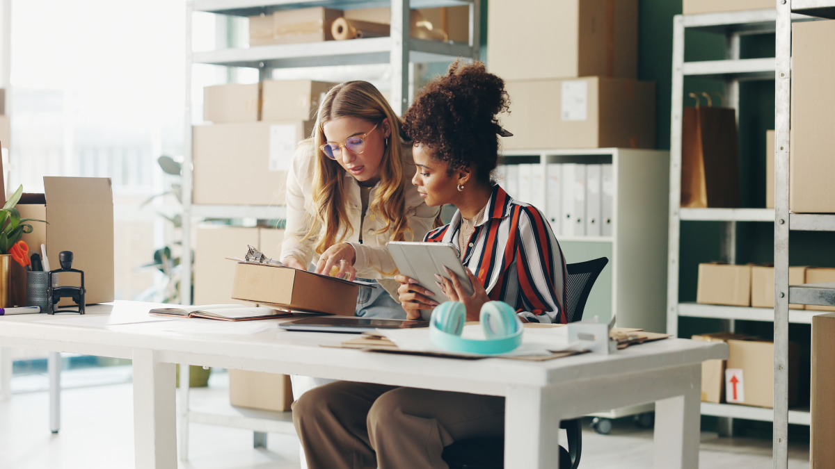 Two person checking stock list on laptop