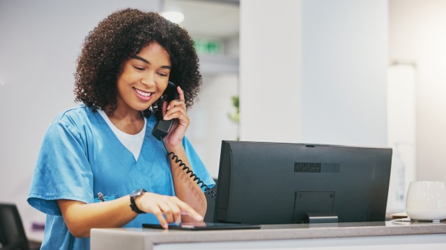 A person is talking on the phone while using a tablet