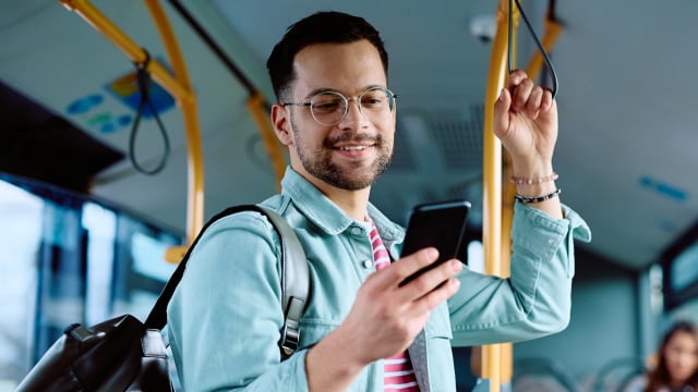 Man looking at mobile phone in transit