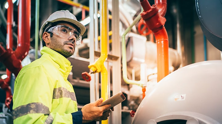 Man in hardhat and safety gear in industrial setting