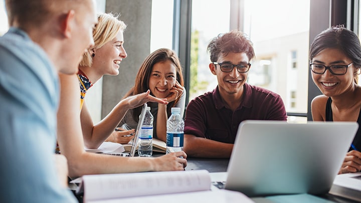 Students discussing around a laptop