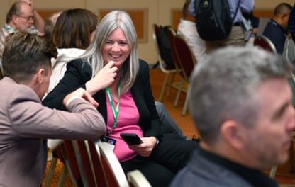 A group of people in an auditorium watching a breakout session