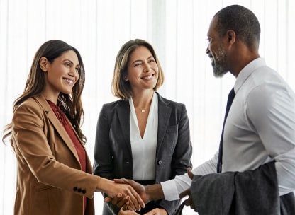 Three people smiling and having a conversation