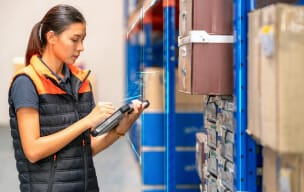 Person checking inventory on a tablet in a warehouse